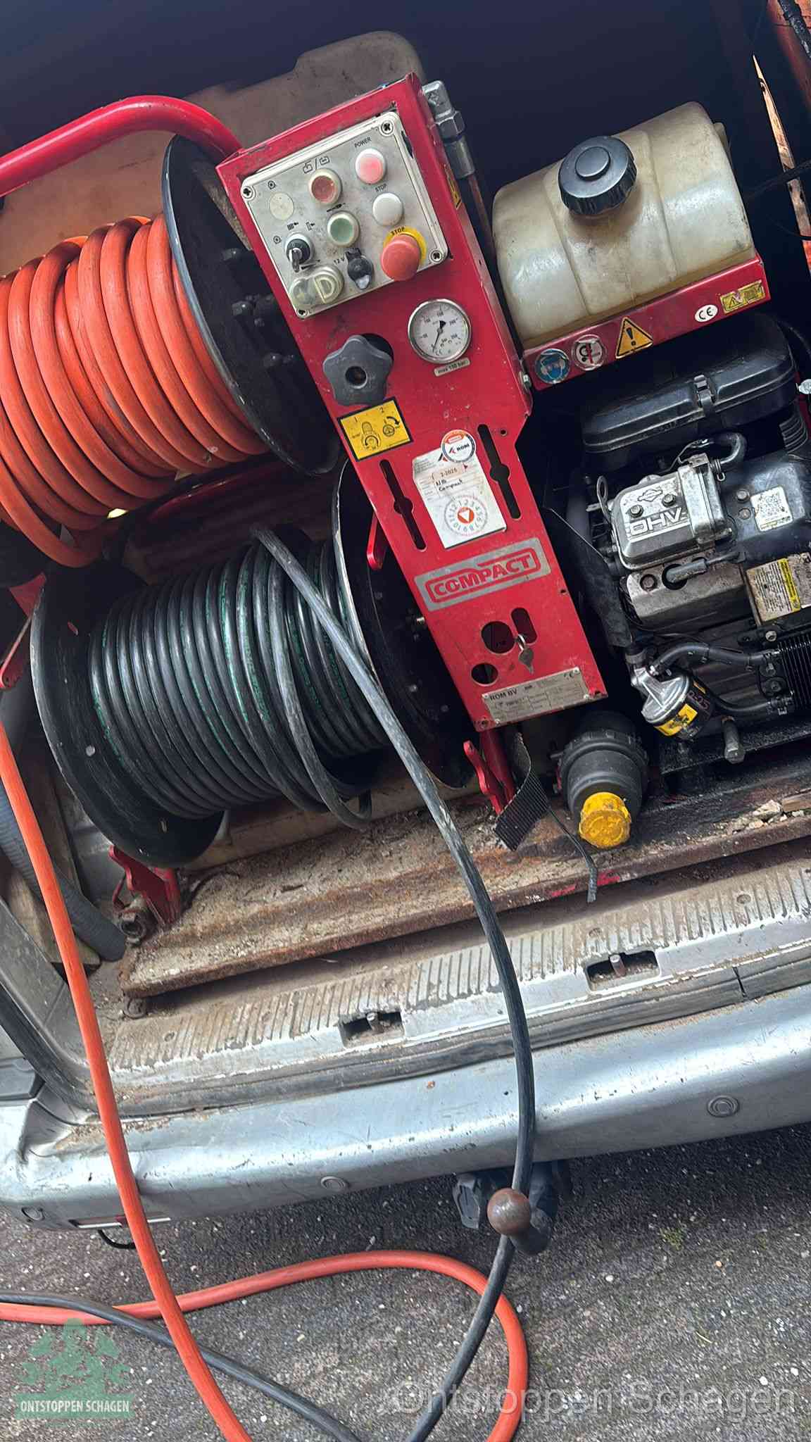 Een rood hogedruk-rioolreinigingstoestel in de laadbak van de bedrijfsbus, apparatuur voor een hardnekkige afvoerverstopping in Schagen