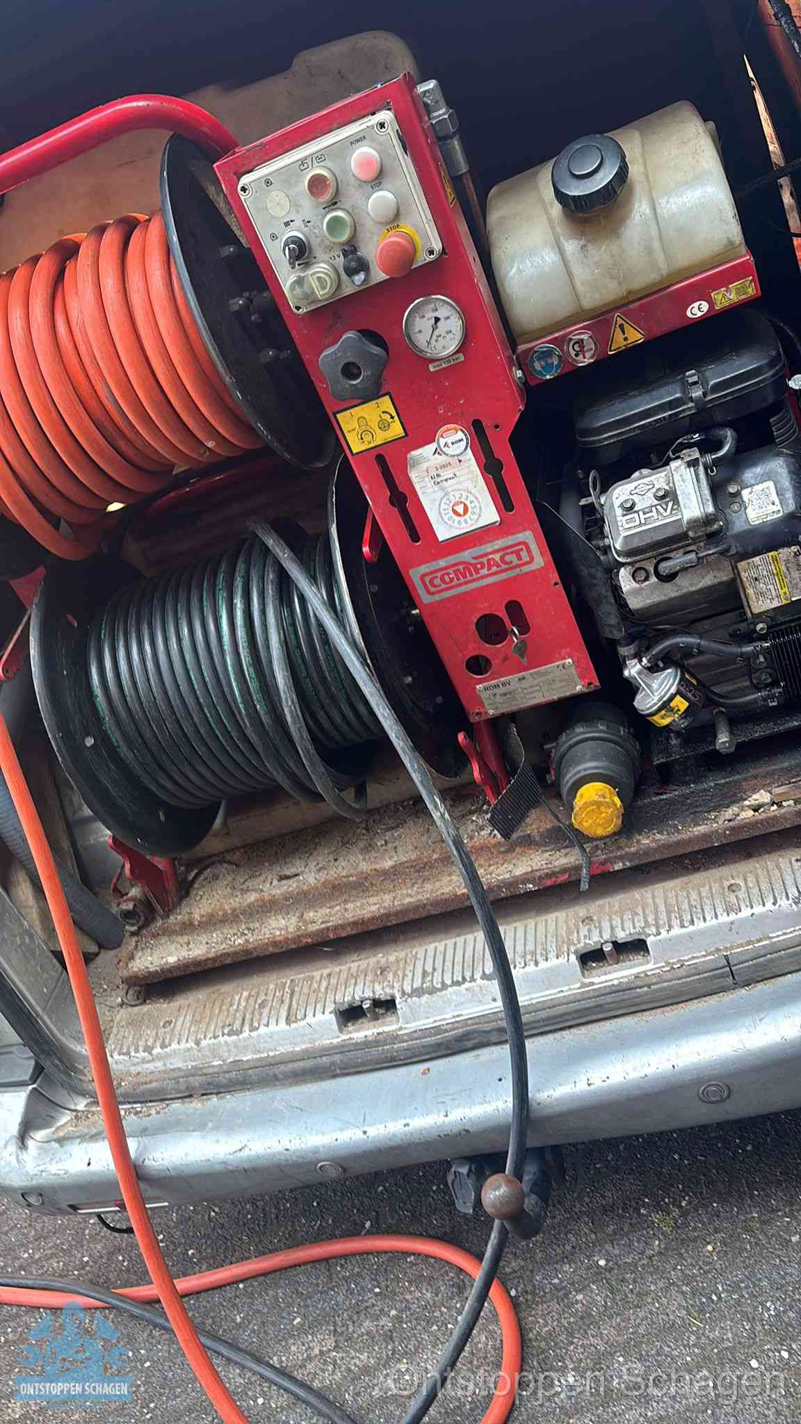 Een rood hogedruk-rioolreinigingstoestel met slangen in de laadbak van de bedrijfsbus, apparatuur voor een hardnekkige wc-verstopping in Schagen