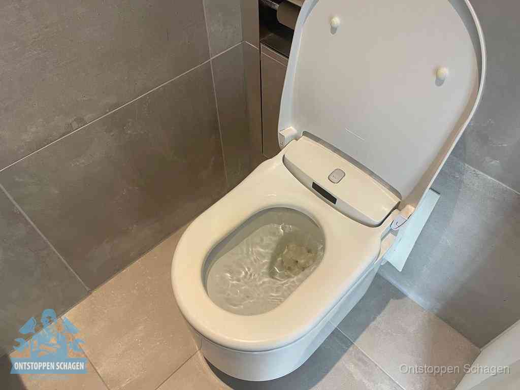 Een toiletpot vol troebel water met drijvend papier en restanten, de meest voorkomende oorzaak van een verstopte wc in Schagen