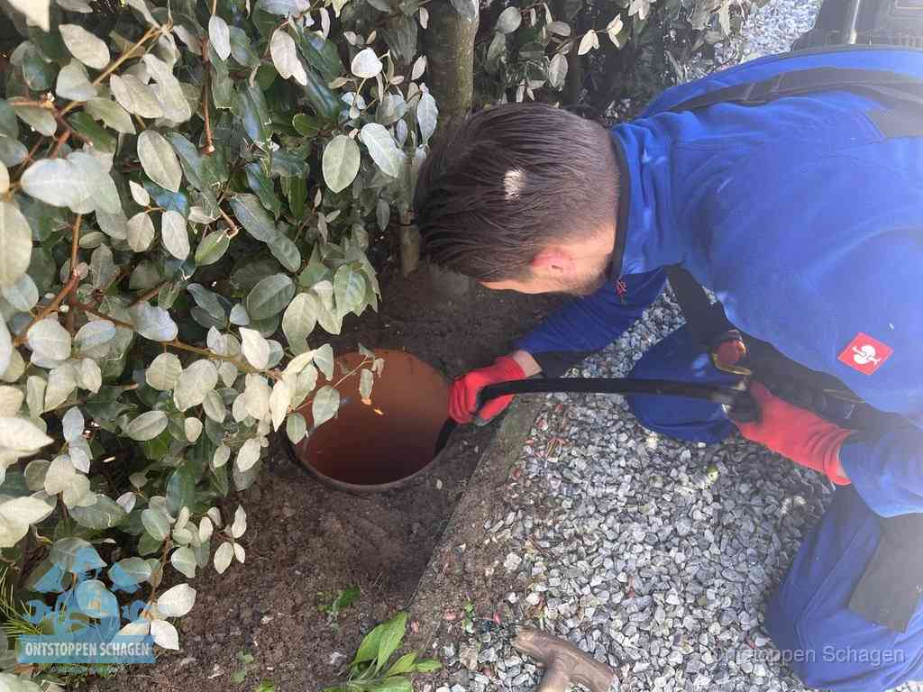 Monteur reinigt een rioolput met een slang, periodieke rioolreiniging in Schagen