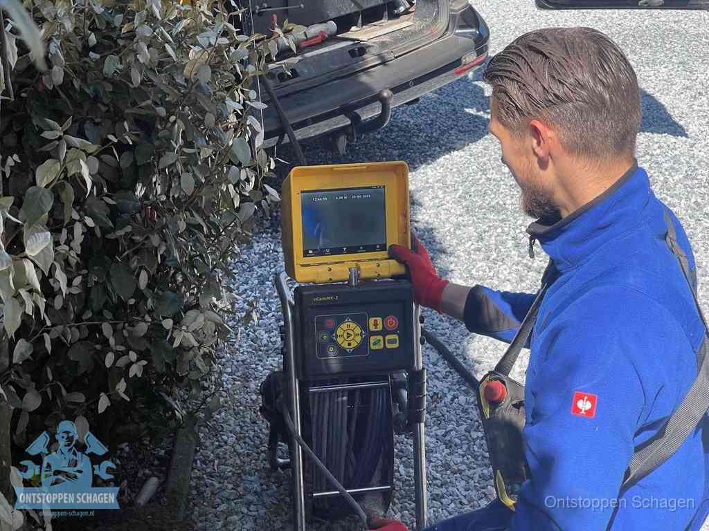 Monteur bedient een rioolinspectiecamera met monitor voor rioolinspectie in Schagen