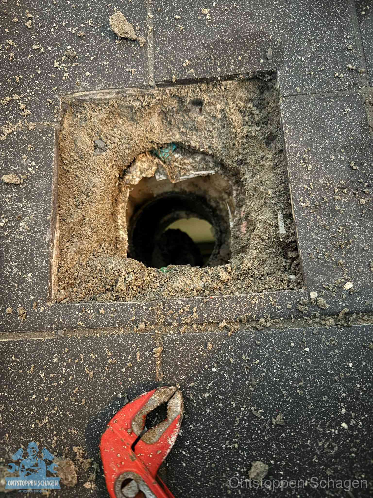 Geopend rioolputje op de erfgrens dat laat zien wie eigenaar is van de riolering in Schagen