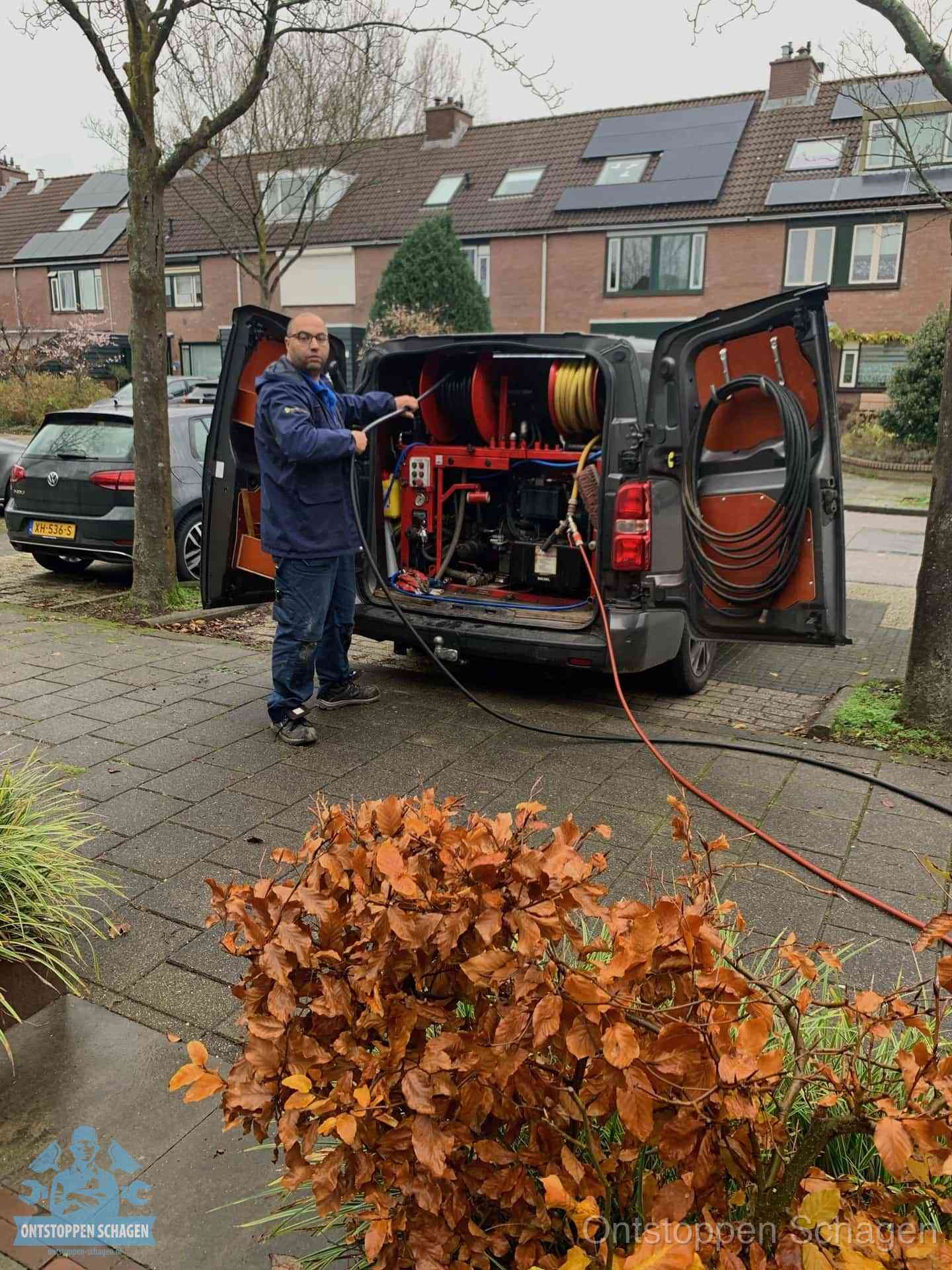 Monteur met rioolreinigingsbus levert rioolservice in de wijk in Schagen