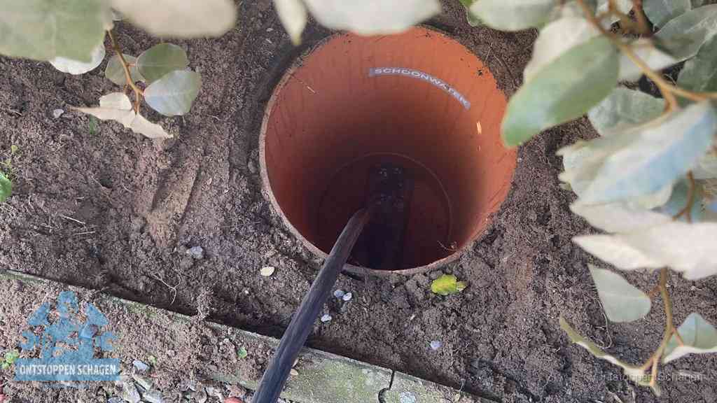 Open inspectieput in de tuin waar een veer rioolvliegjes en stankoverlast aanpakt in Schagen