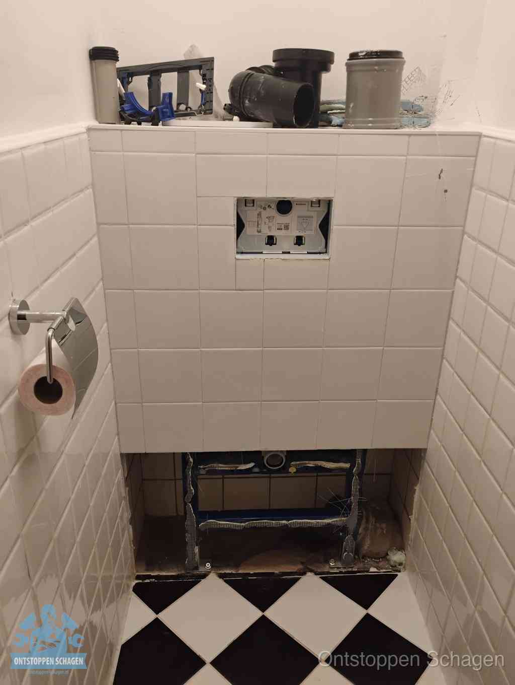 Een toiletruimte waar het hangtoilet en de inbouwreservoir-onderdelen zijn vrijgelegd voor onderhoud, periodiek nazicht voorkomt een wc-verstopping in Schagen