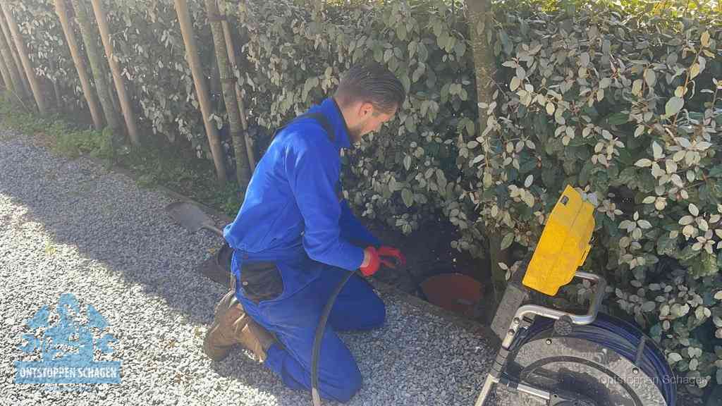 Monteur aan het werk bij een rioolput, de werkwijze voor riool ontstoppen in Schagen